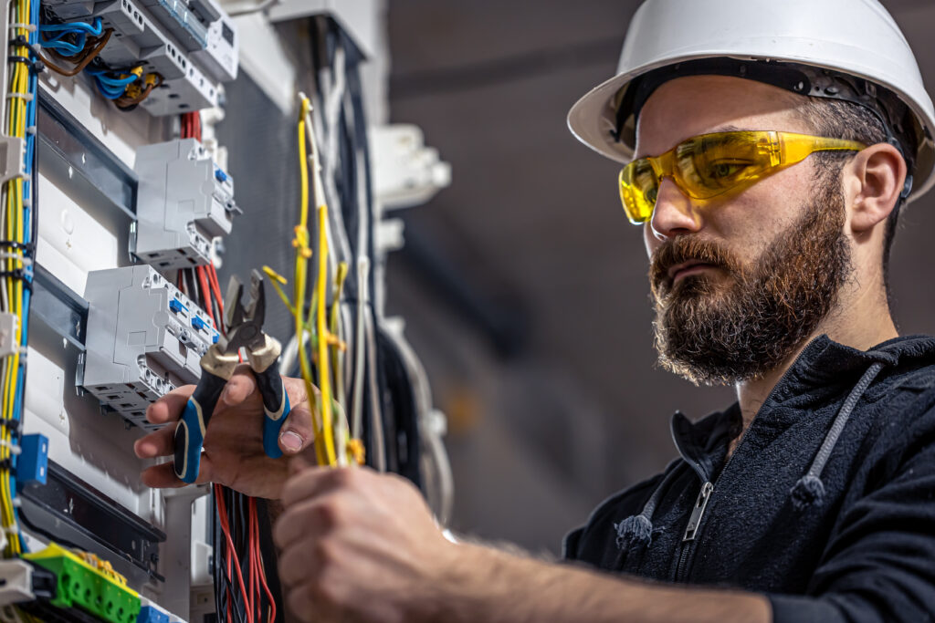 Electrician working on electrical wiring inside a residential building.