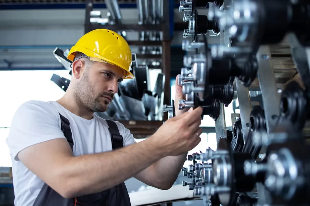 A skilled mechanical fitter adjusting heavy machinery components in an industrial setting, demonstrating expertise typical of Mechanical Fitter Jobs.